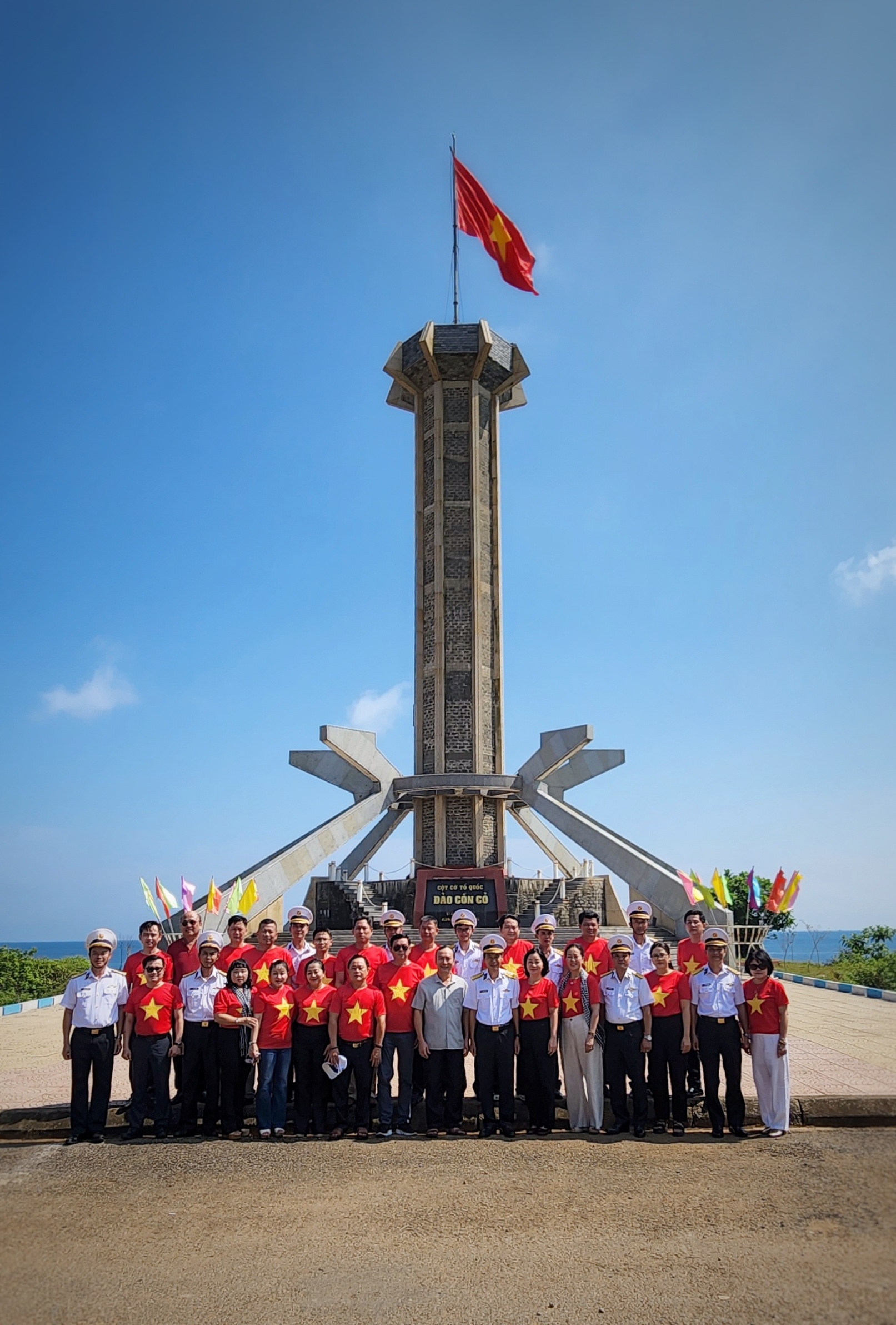 Đoàn công tác của Ban Chỉ đạo Công tác Thông tin đối ngoại tỉnh Bình Dương chụp ảnh lưu niệm tại Cột cờ đảo Cồn Cỏ.